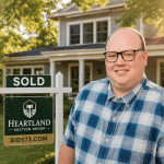 Homeowner with sold property and Heartland Auction Group sign in front of house.
